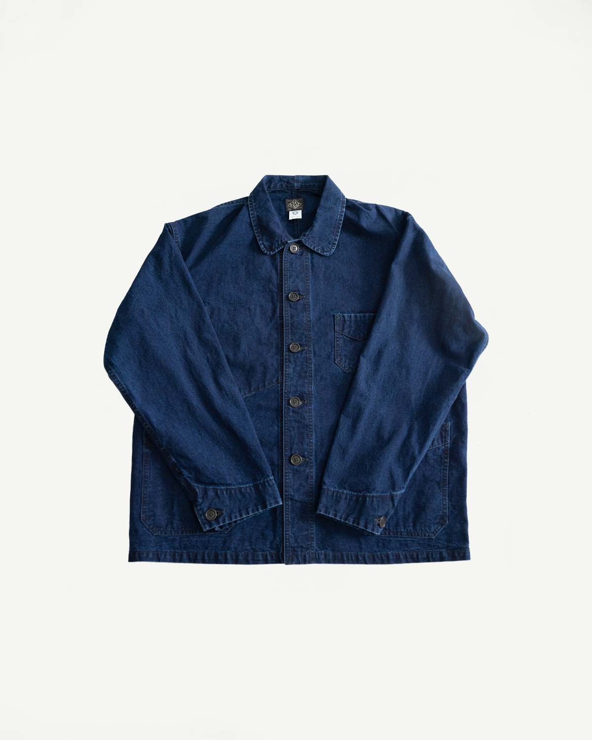 Flat lay front view of indigo washed canvas chore jacket, button front, single chest pocket, pointed collar.