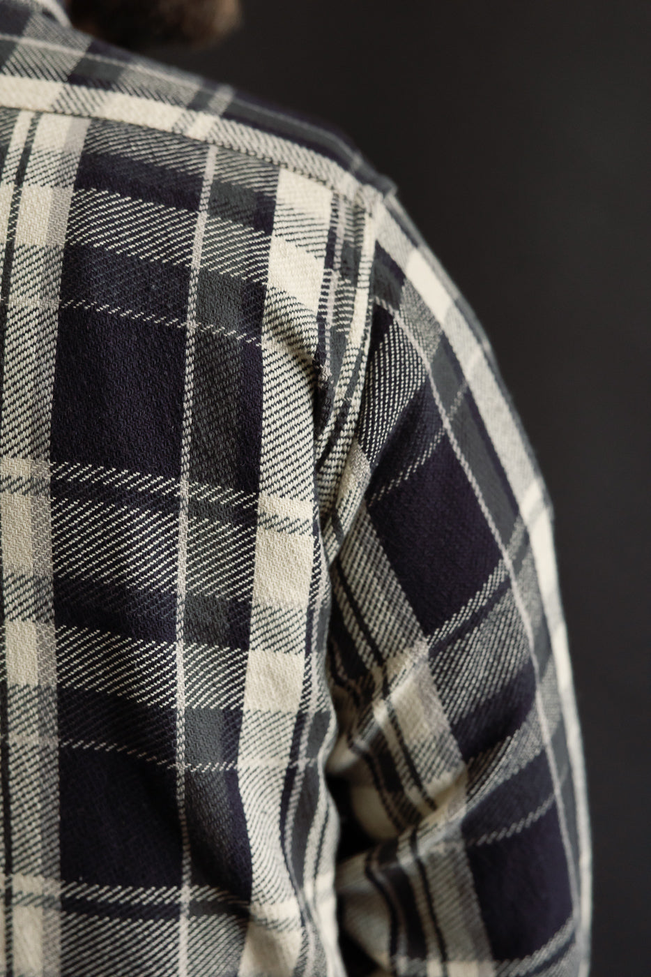 Close-up of St Louis grey cotton flannel plaid shirt back shoulder, texture detail, on male model