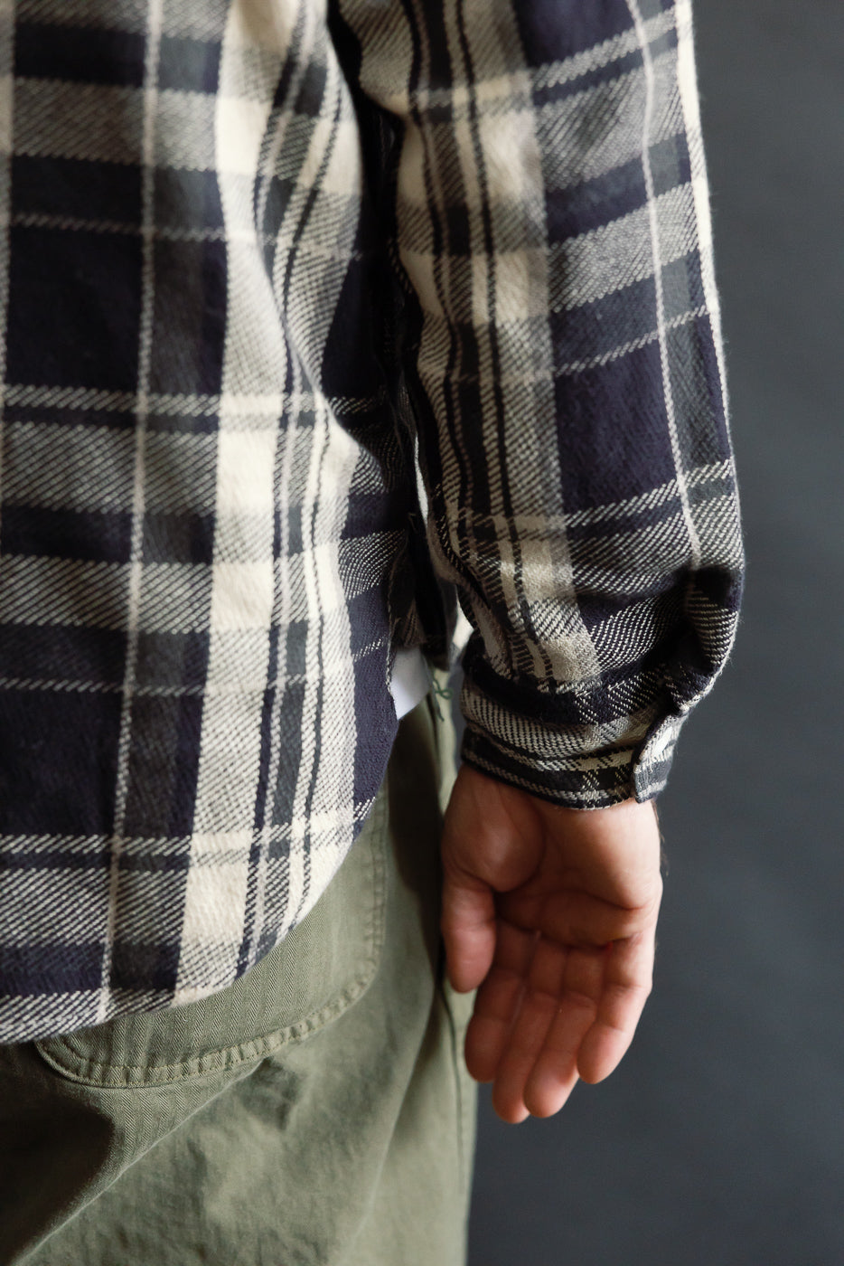 Close-up of male model's right side wearing grey plaid cotton flannel shirt sleeve, Dant