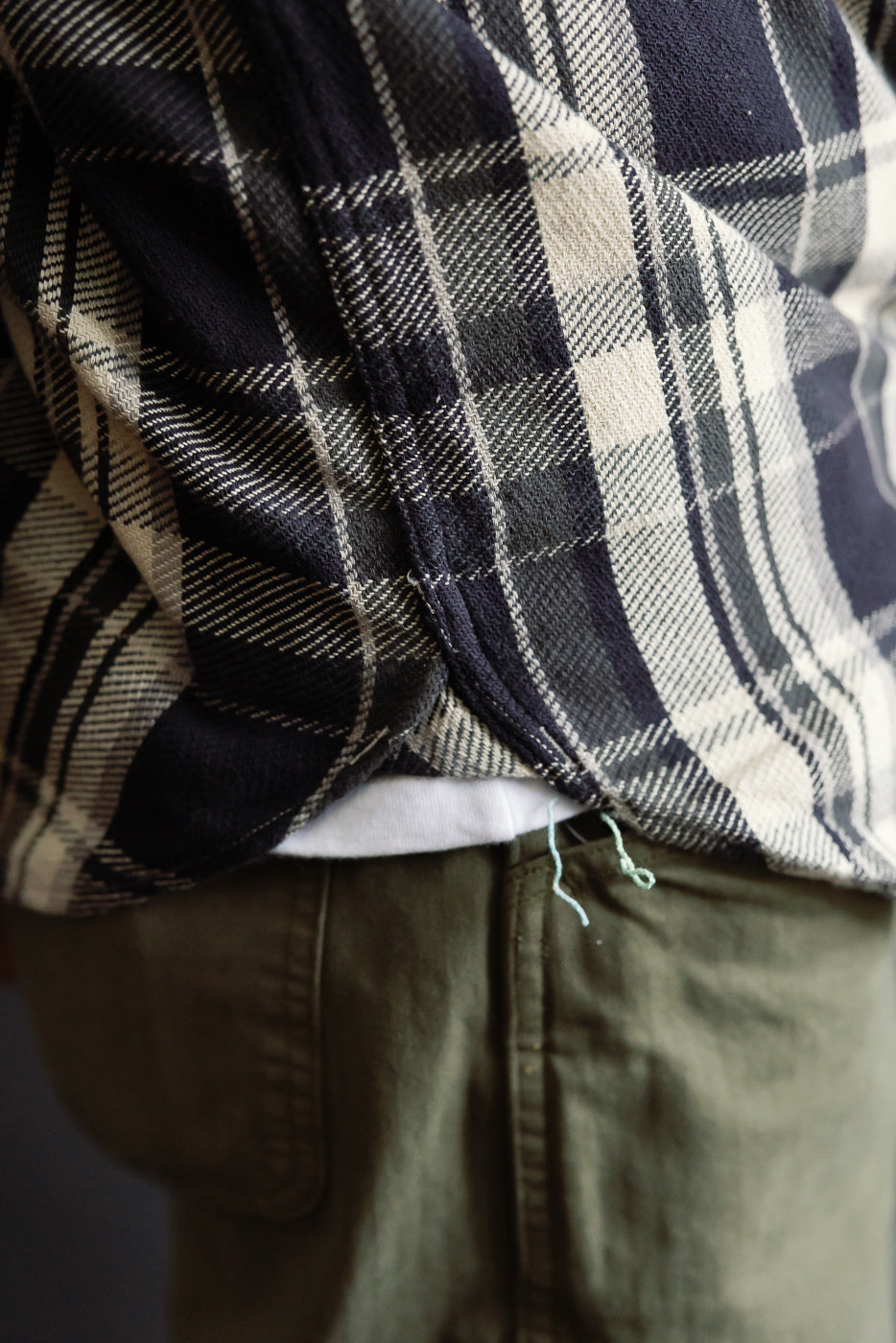Close-up of side hem detail, Post O'Alls St. Louis grey cotton flannel plaid shirt on male model