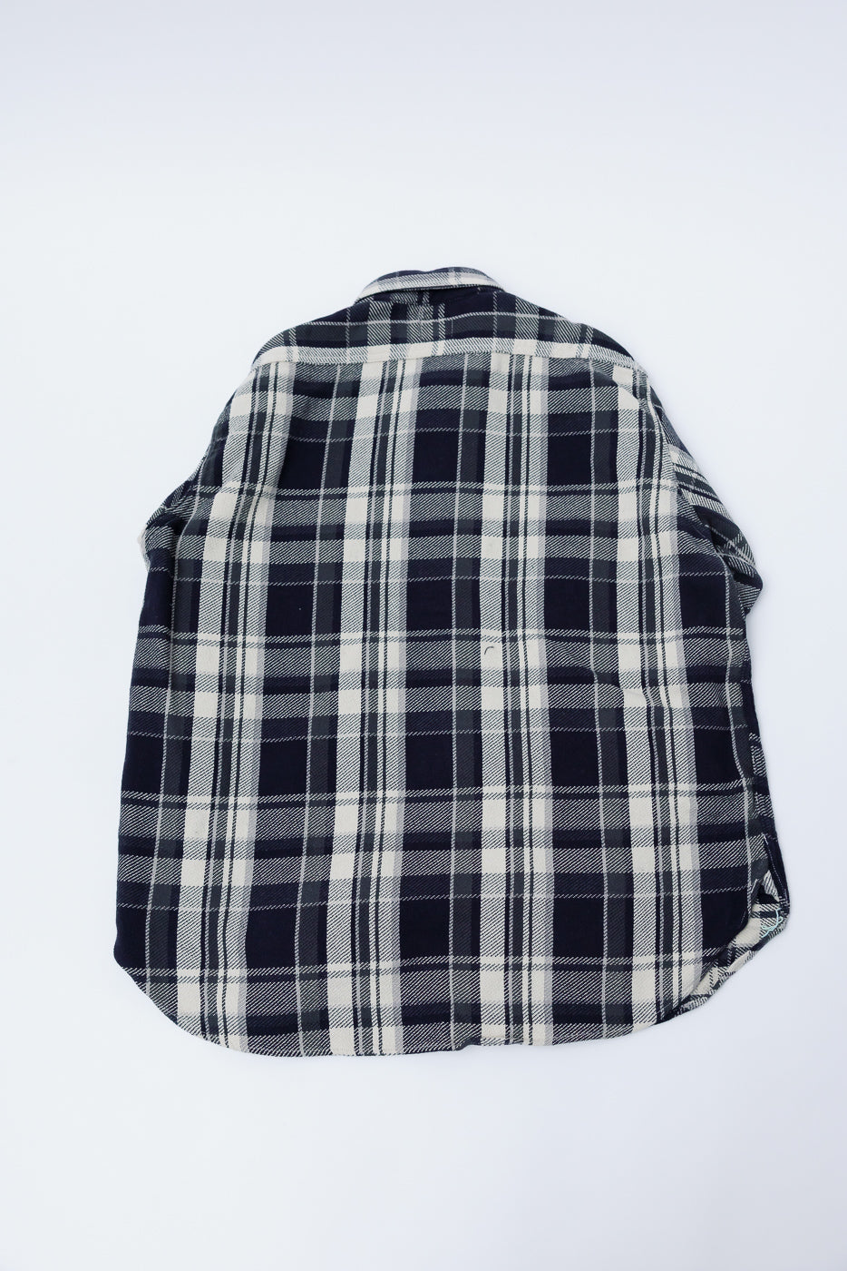 Back view flat lay of grey plaid cotton flannel shirt, highlighting fabric texture and hem.