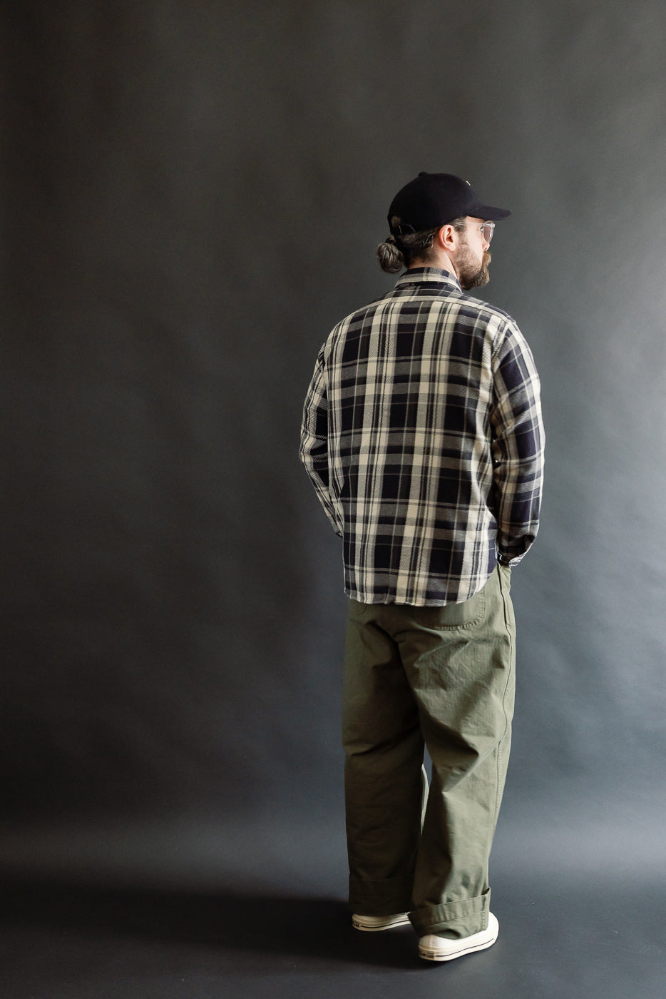 Male model 5'9, 165lbs wearing grey plaid cotton flannel shirt, back view, full body