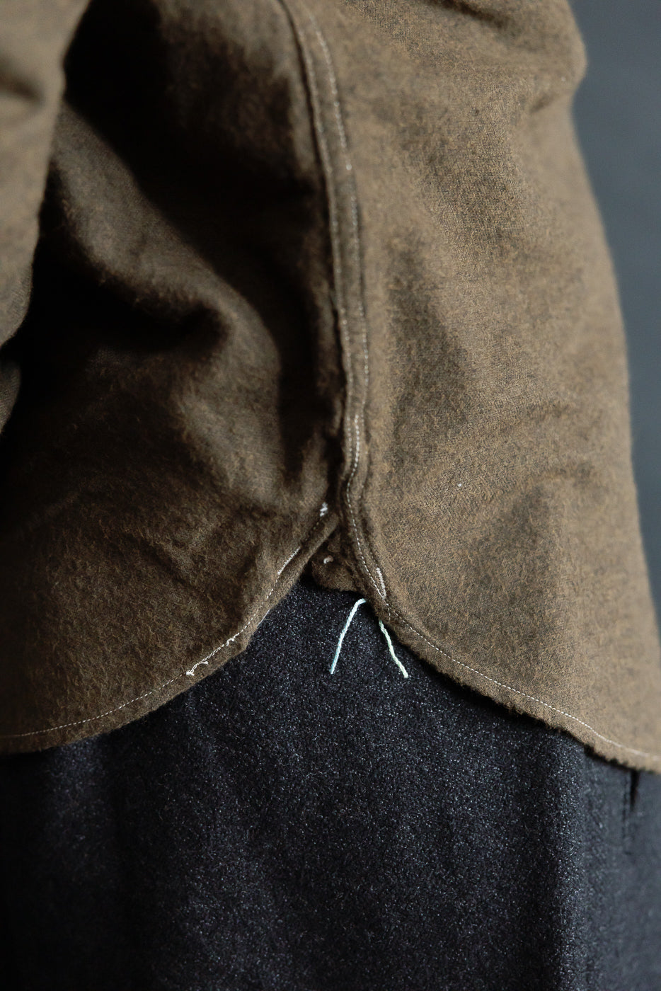 Close-up of Post O’Alls St. Louis Band cotton flannel shirt hem side detail in tobacco color