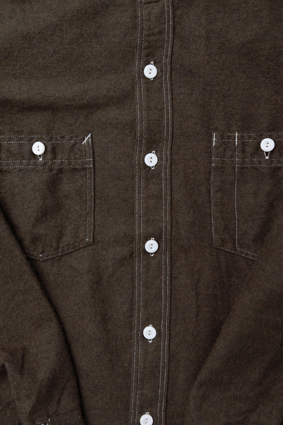 Close-up front of brown heather cotton flannel shirt, chest pockets, white buttons, contrast stitching