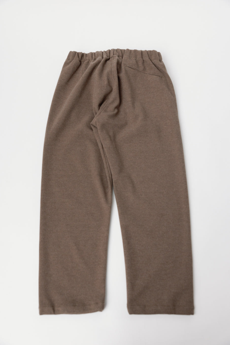 Flat lay of Post O'Alls Coach Pants in brown sweat cloth, back view highlighting pocket and elastic waistband, casual menswear at Dant.