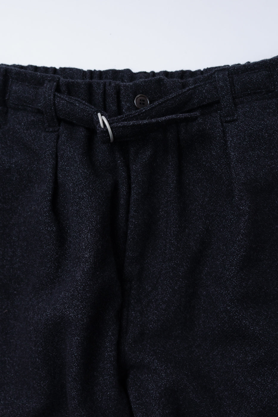 Close-up of front waistband and fly area on Post O’Alls charcoal basket tweed pants, showing button and belt loop details, for Dant contemporary apparel.