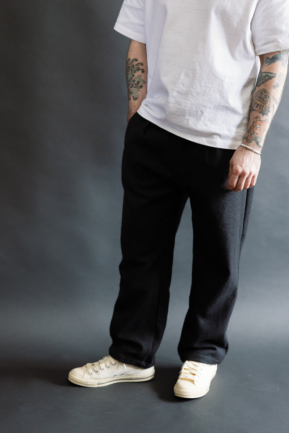 Male model 5'9, 165lbs, athletic build wears charcoal tweed pants, front view, full body