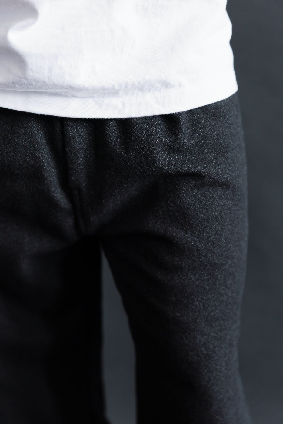 Close-up front view of Post O'Alls charcoal tweed pants waistband on male model, 5'9