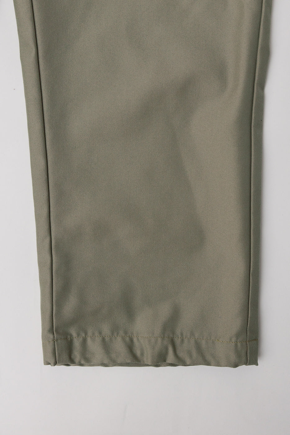 Close-up of khaki French twill pants front hem showing fabric texture and stitching detail