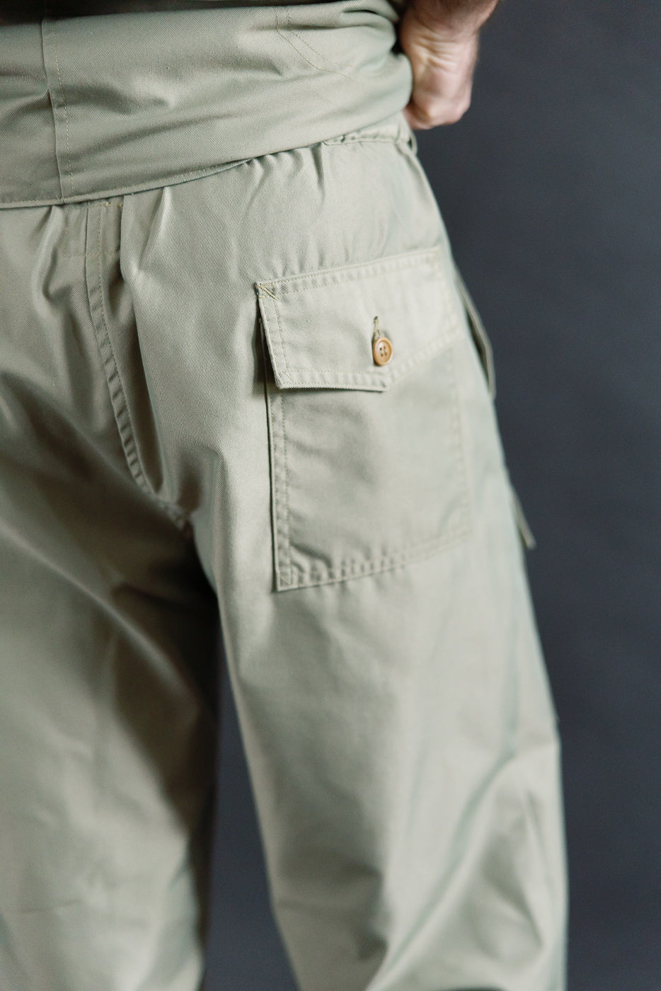 Close-up of back side of men's khaki French twill pants on 5'9 athletic male, buttoned flap pocket detail