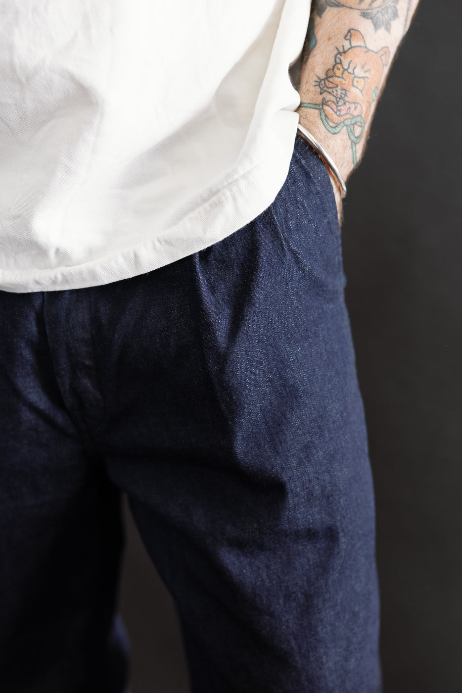 Close-up front view of 8oz dark indigo denim pants on male model, 5'9
