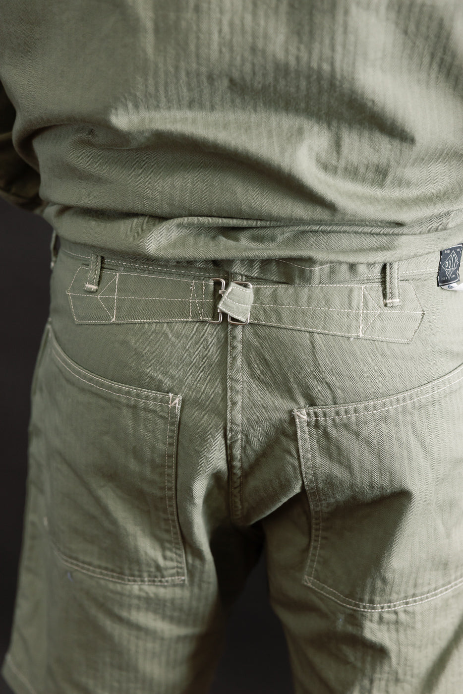 Close-up of back of sage green herringbone shorts, male model 5'9