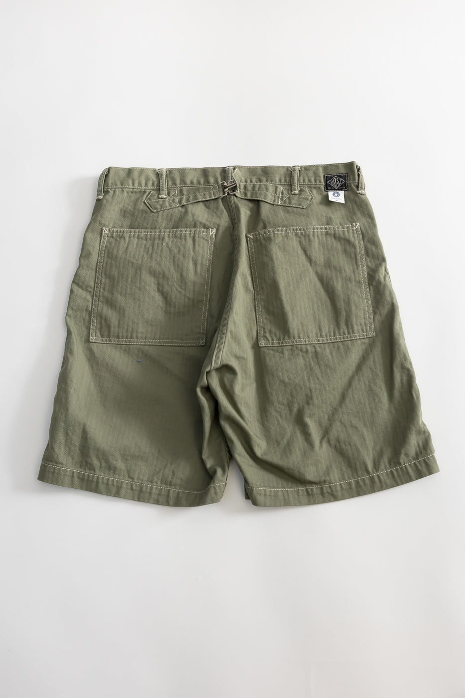 Flat lay, back view of sage green men's shorts with dual rear patch pockets and belt loops