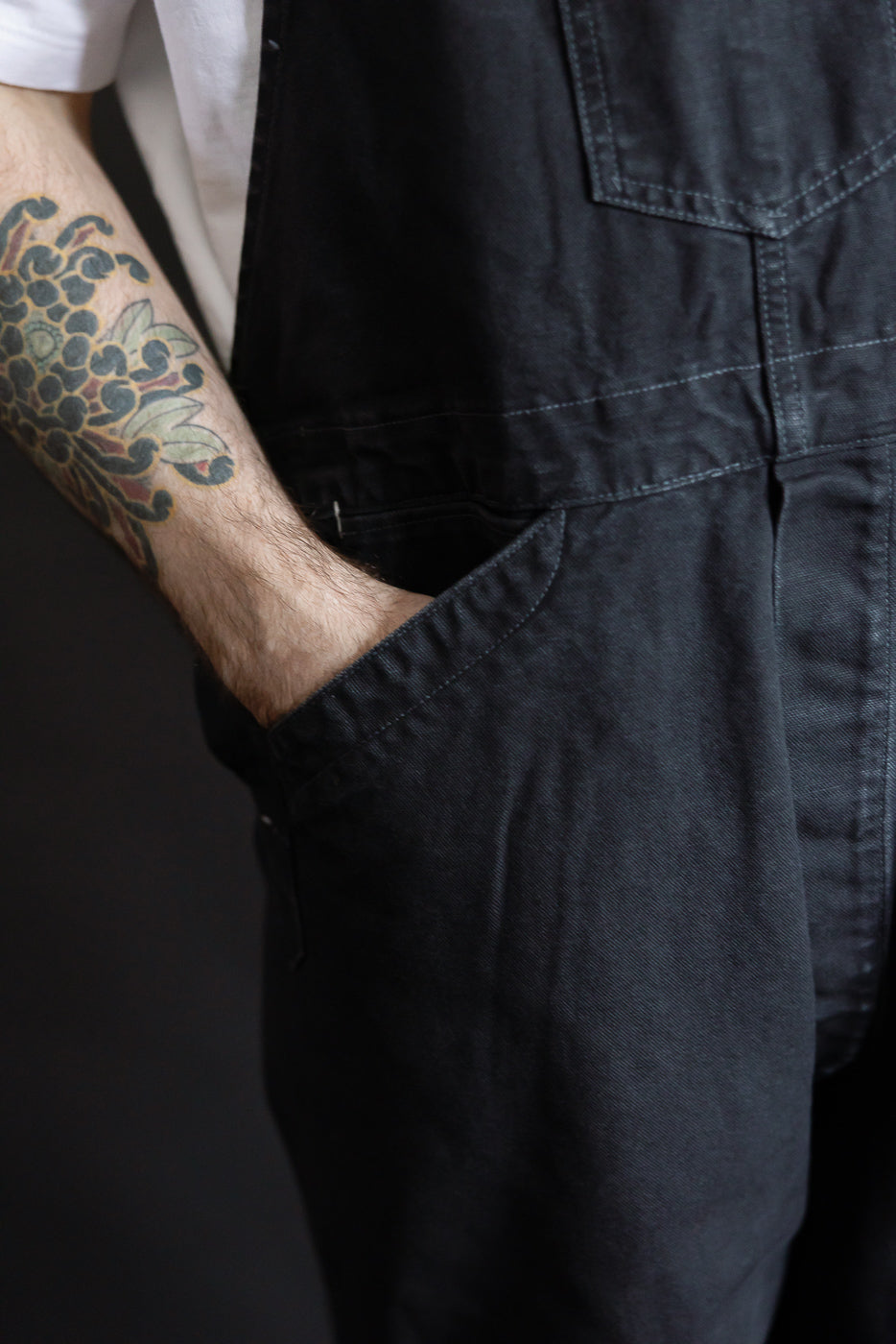 Close-up of black pigment-dyed canvas overalls front pocket, male model 5'9
