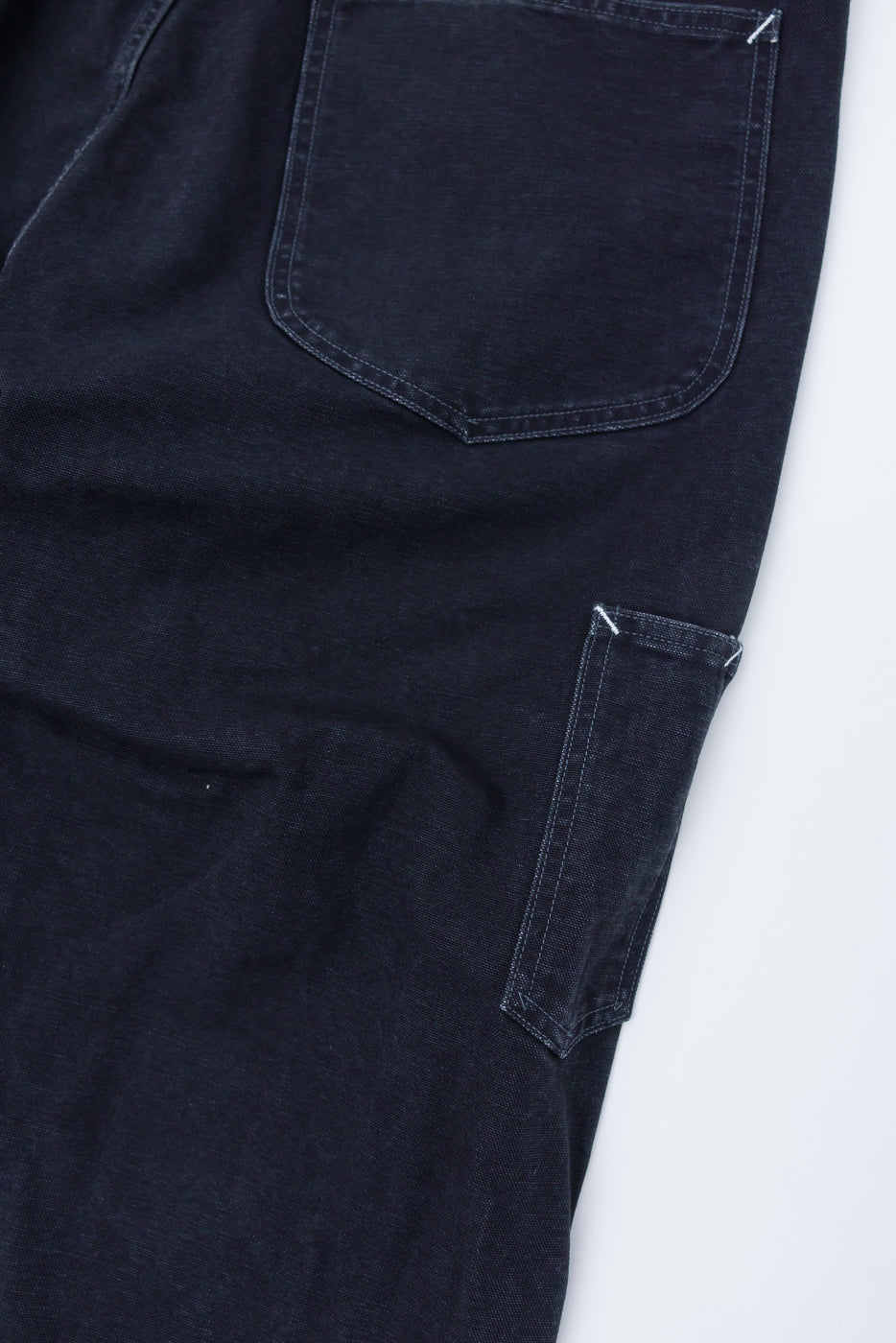Close-up of Post O’Alls Post 46 black pigment dyed canvas overalls, rear pocket and side leg detail.