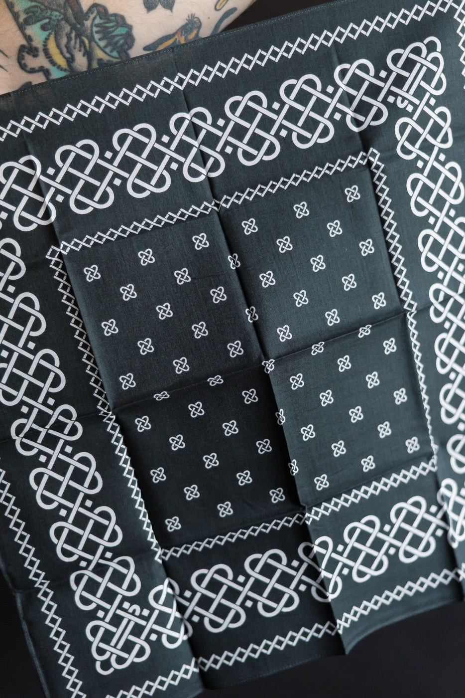 Close-up of Post O'Alls charcoal bandana featuring rope knot pattern and small repeats, front side.