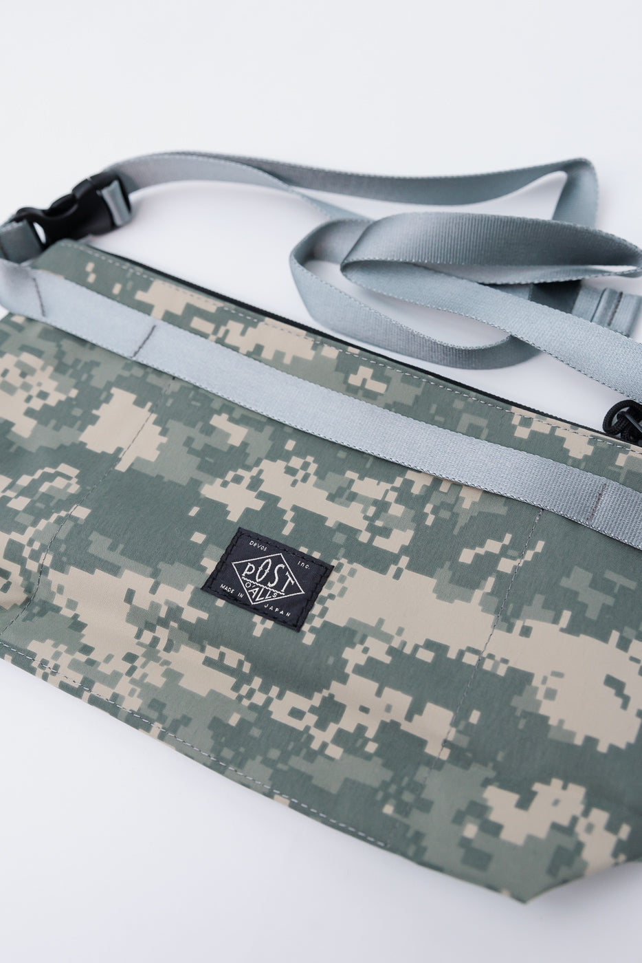Close-up of Post O'Alls x Bagsinprogress fanny pack front in digital desert camo with gray strap and logo patch