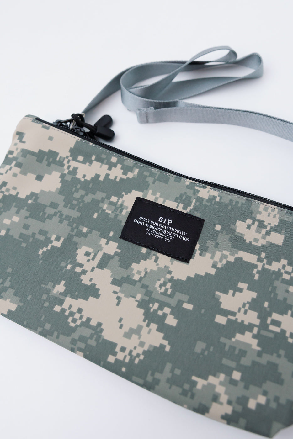 Close-up of front of digital camo desert crossbody fanny pack with BIP patch, flat lay