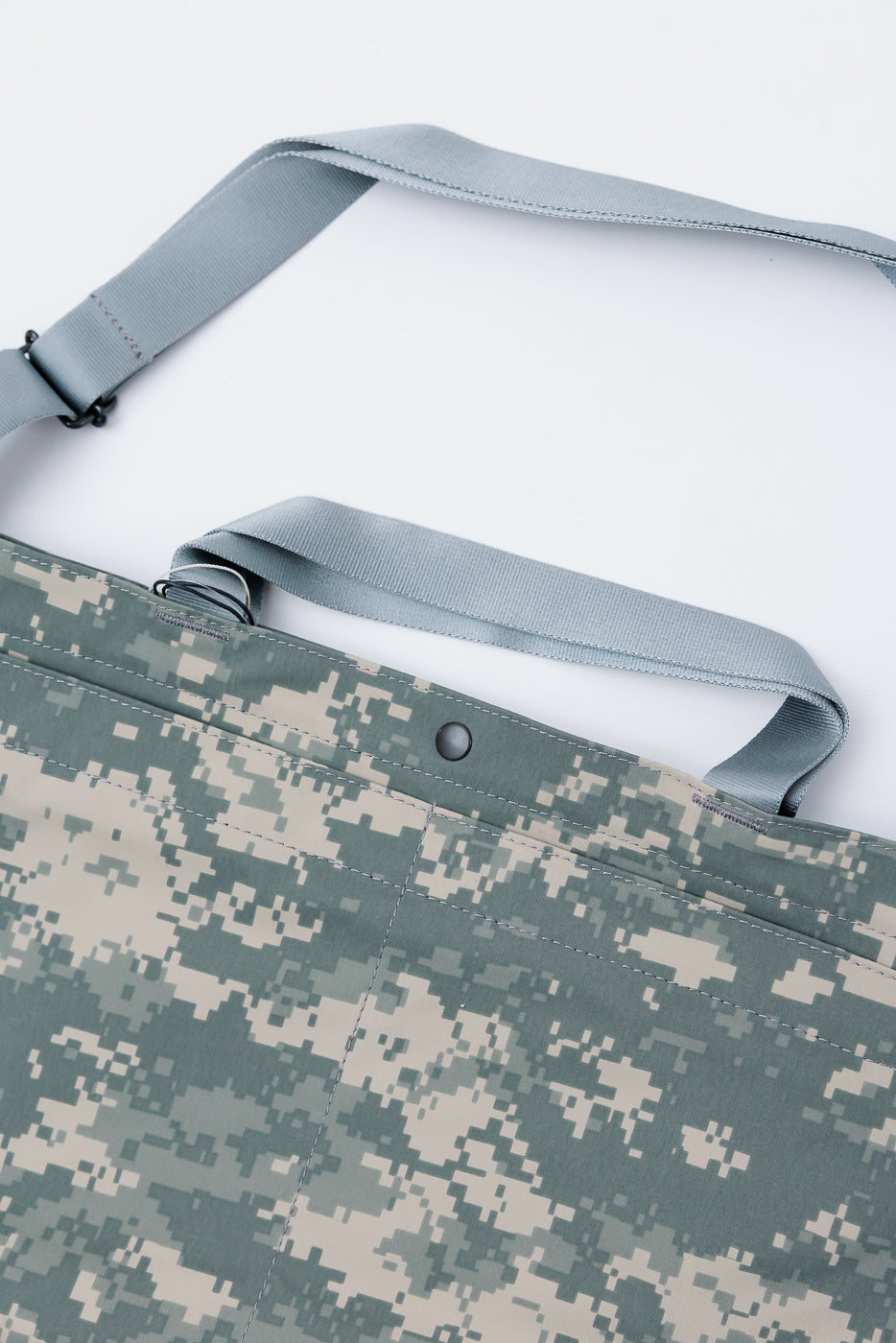 Close-up front view of Post O'Alls Gore-Tex digital camo desert tote bag with grey straps and snap detail, contemporary accessory at Dant.