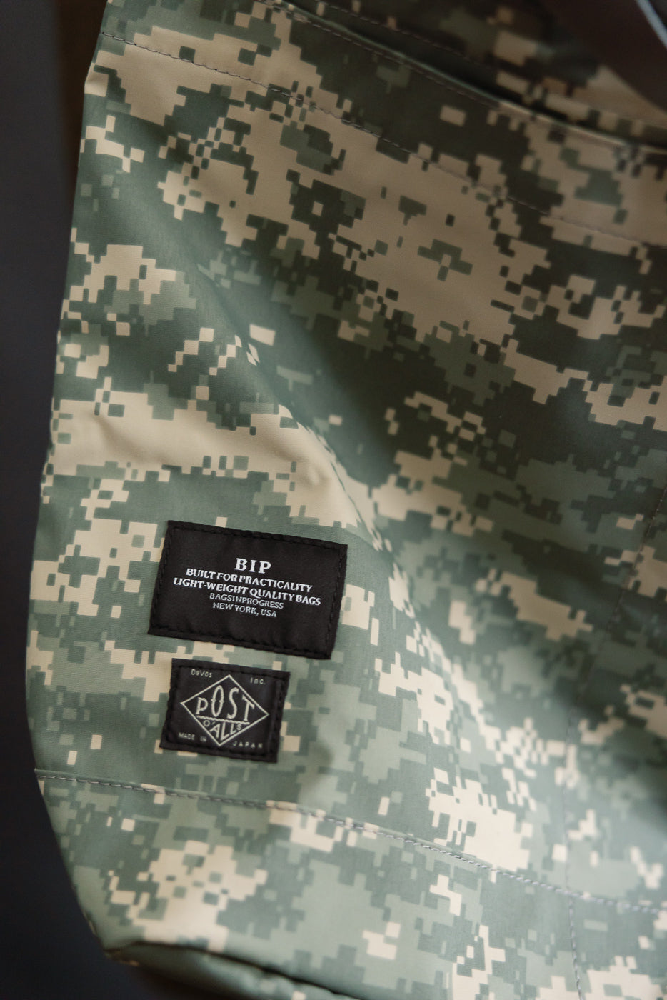 Close-up of Post O'Alls New York Tote in desert digital camo showing Gore-Tex fabric and brand tags