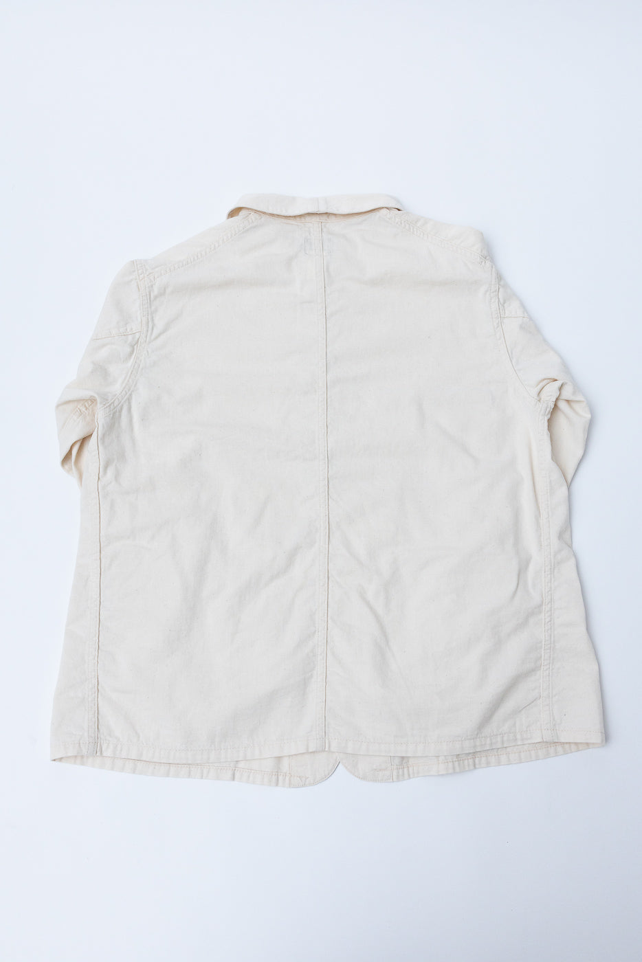 Flat lay of cream mid-weight denim shirt, back view, showing collar and seam details.