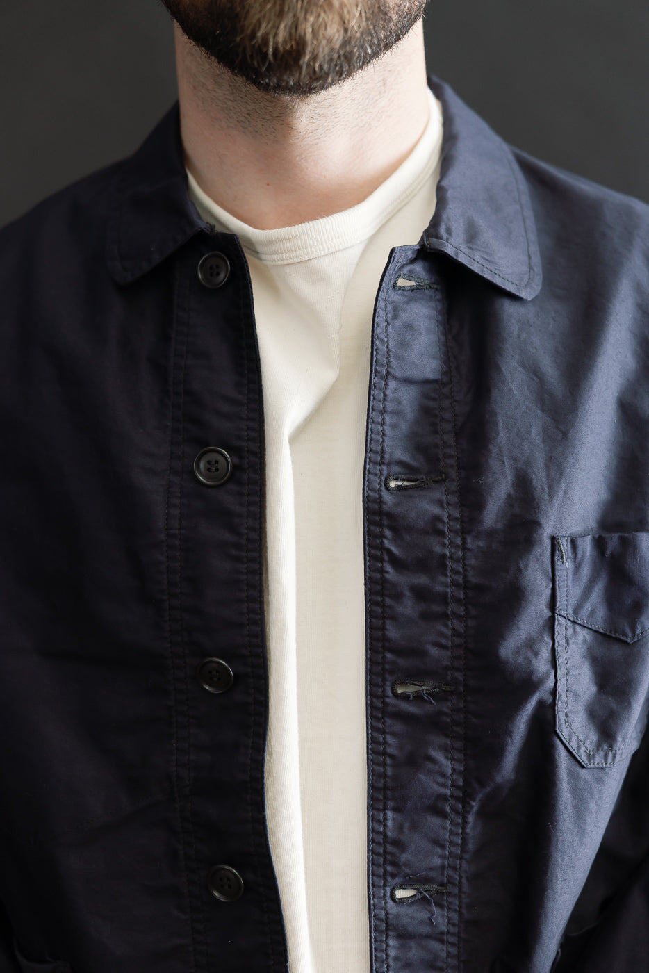 Man wearing the 3135-LMN - Post Chinois Travail 2 Light Moleskin jacket in dark navy, a cropped coverall-style jacket with a rounded collar, button-front, and patch pocket, showcasing detailed craftsmanship.