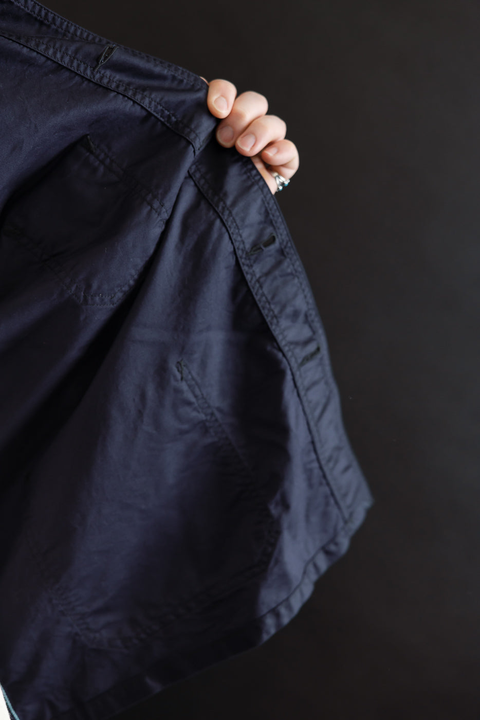 Post Chinois Travail 2 jacket in dark navy, showcased open to reveal its interior lining, stitching, and pocket details. The jacket’s cropped workwear style embodies a blend of French-Chinese sensibility.