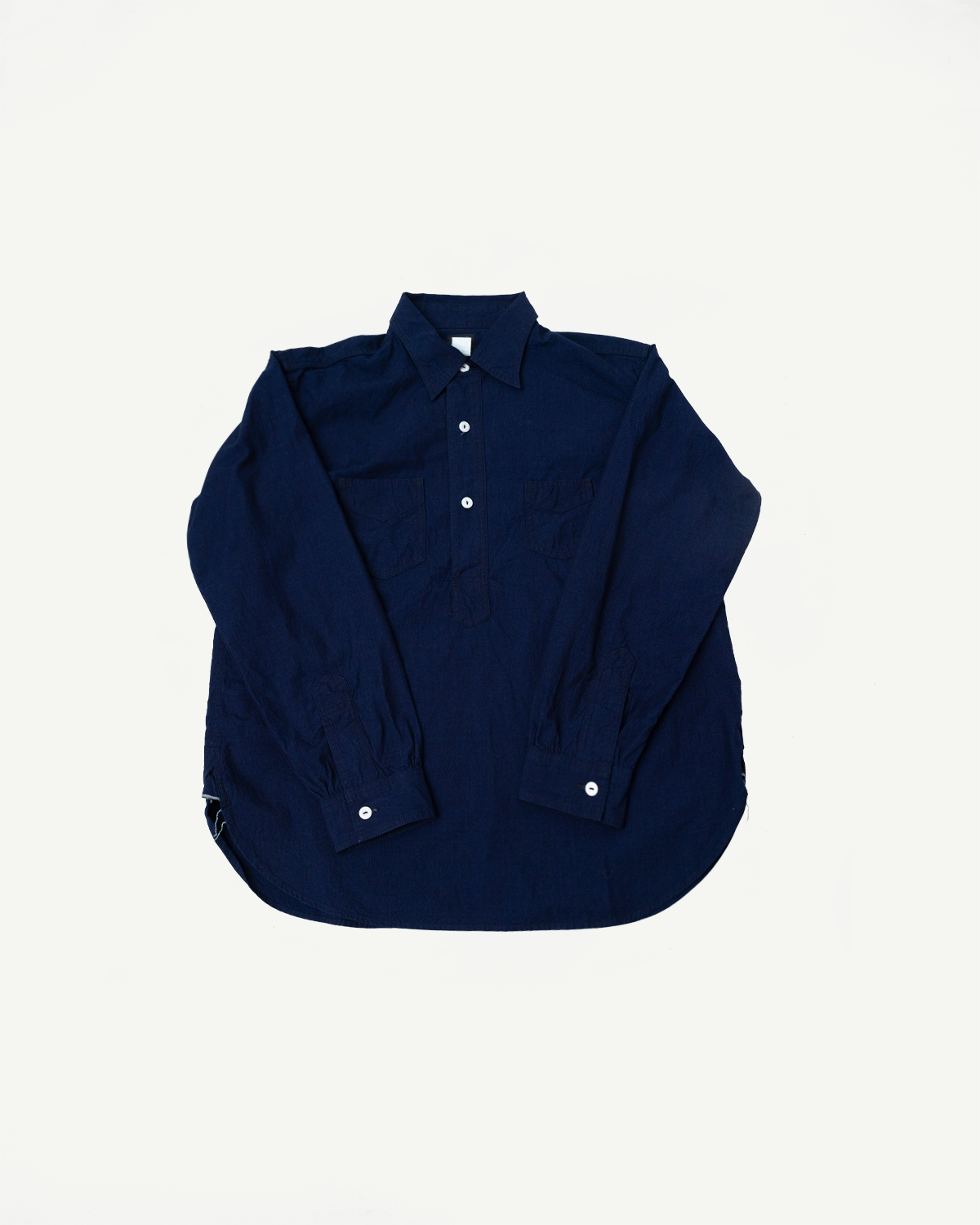 Flat lay of front of dark indigo long sleeve shirt, showing buttons, collar, and chest pockets.