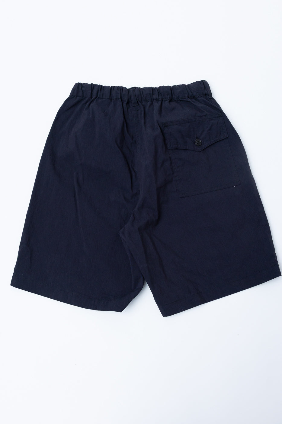 Flat lay of navy 60/40 twill shorts, back view, showing elastic waistband and back button pocket