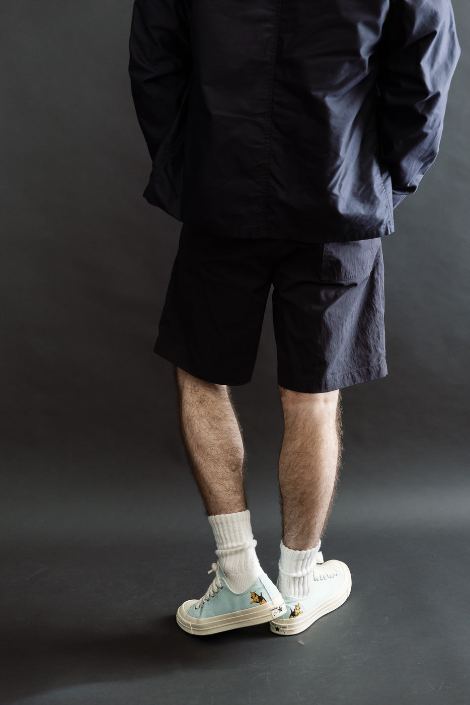 Back view, mid-length of navy 60/40 twill shorts on male model, 5'9, 165lbs, athletic build