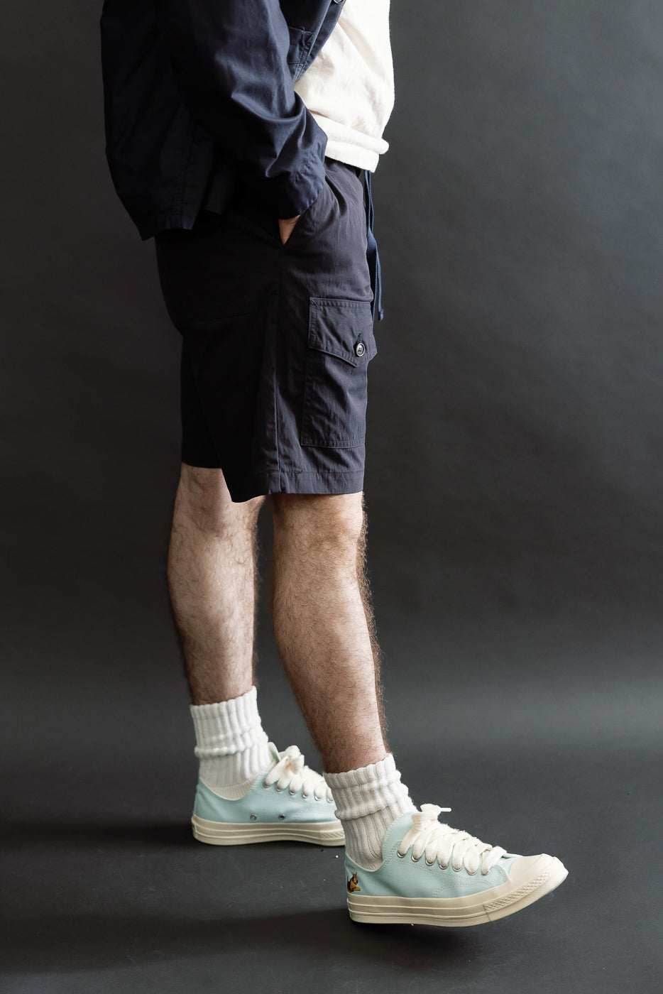 Side view of navy cargo shorts on male model, 5'9