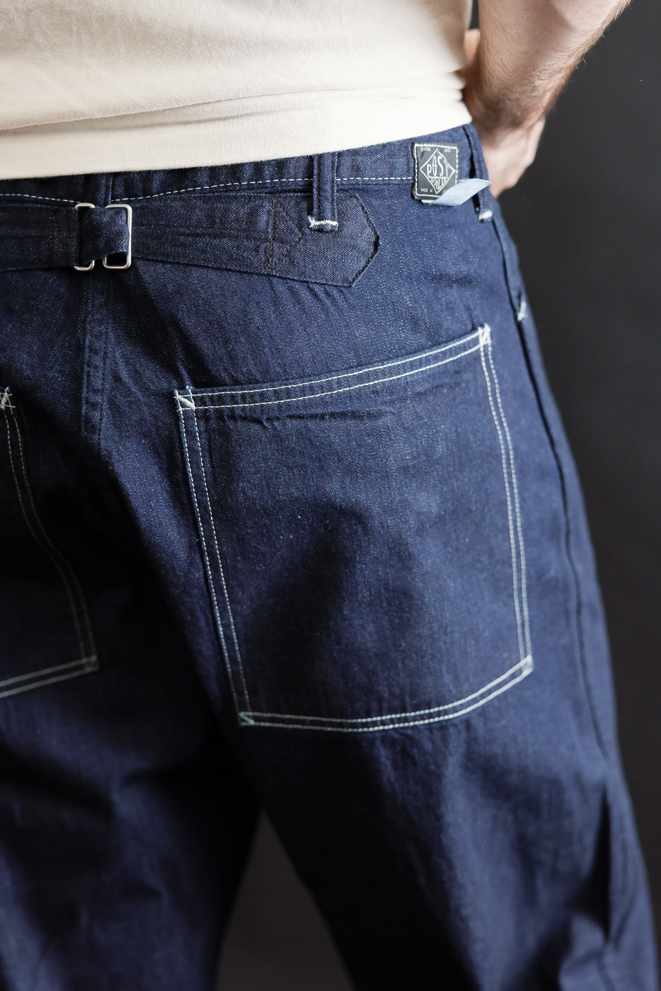 Close-up rear view of 8oz dark indigo denim pants on male model, 5'9