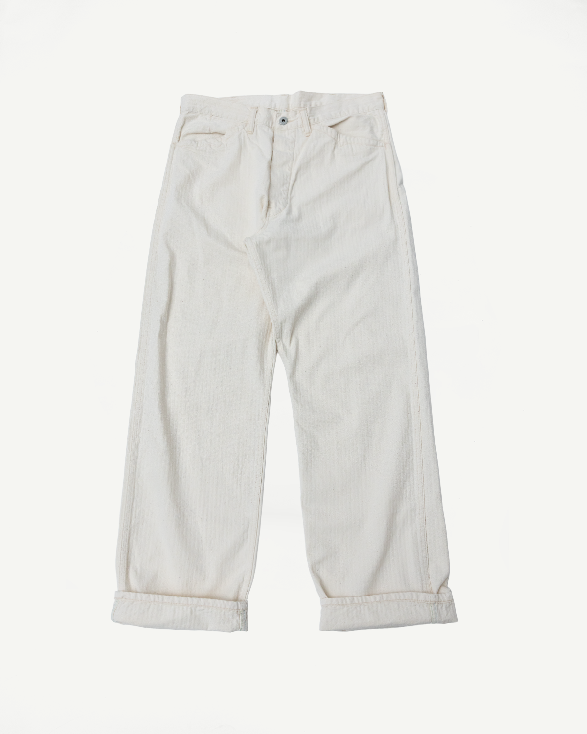 Flat lay front view of natural color herringbone twill pants, cuffed hem, button fly, no model.