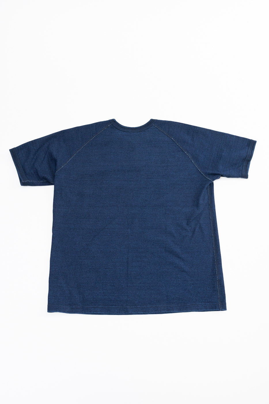 Flat lay back view of navy raglan tee, showing seam details and hem, selvedge fabric texture