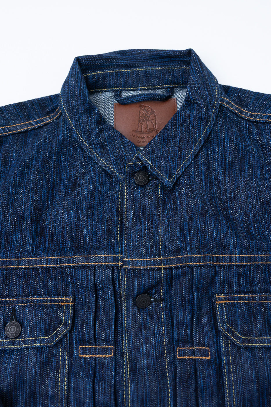 Close-up of the 6225-D - 14.5oz Dark Waterfall Selvedge Type 2 Jacket - Indigo, highlighting its point collar, chest pockets with snap-buttons, contrast stitching, and visible leather brand patch inside the collar.