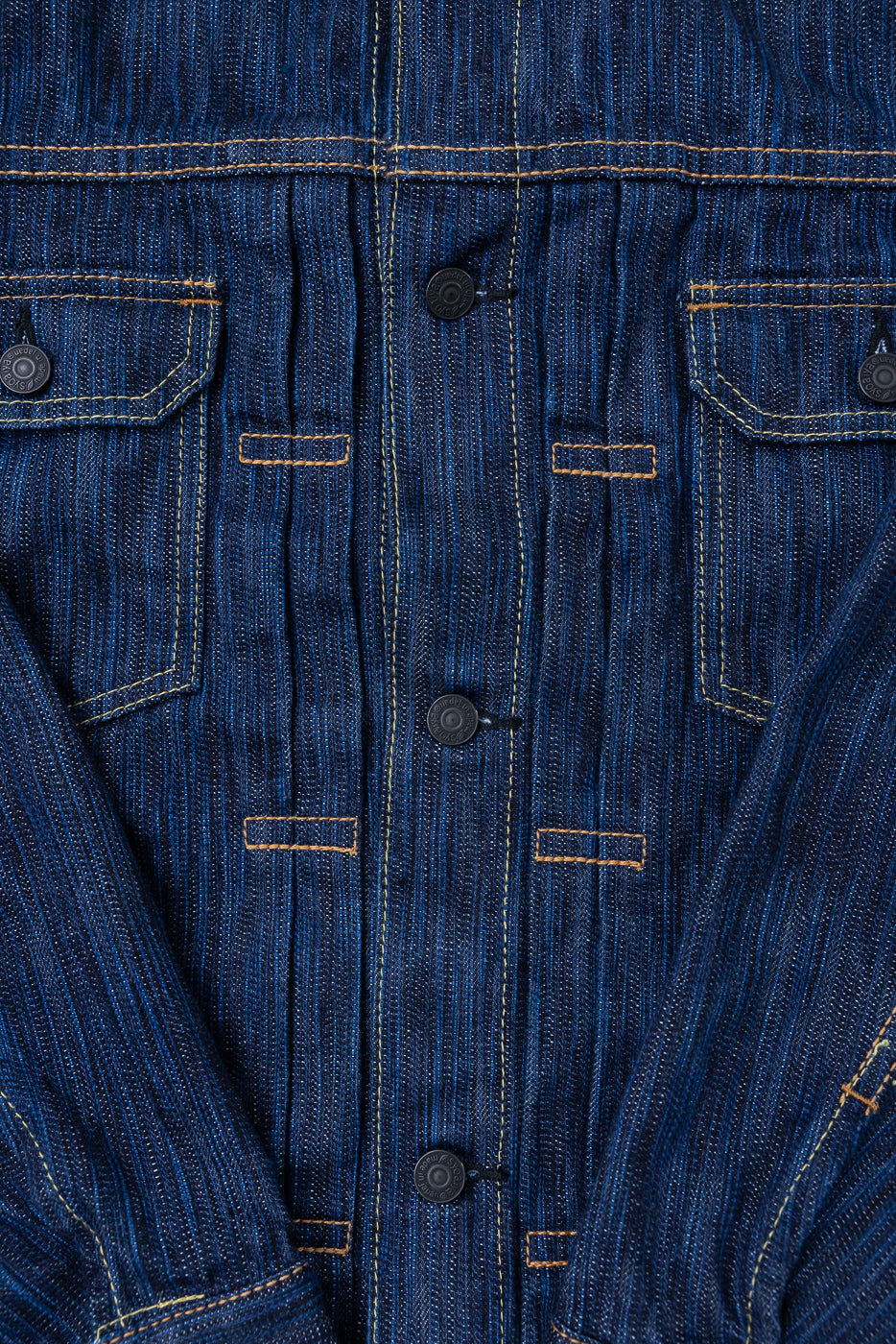 Close-up of the 6225-D - 14.5oz Dark Waterfall Selvedge Type 2 Jacket, showcasing the textured indigo denim, snap-button placket, flap chest pockets, and contrasting top-stitching, highlighting its artisanal craftsmanship.