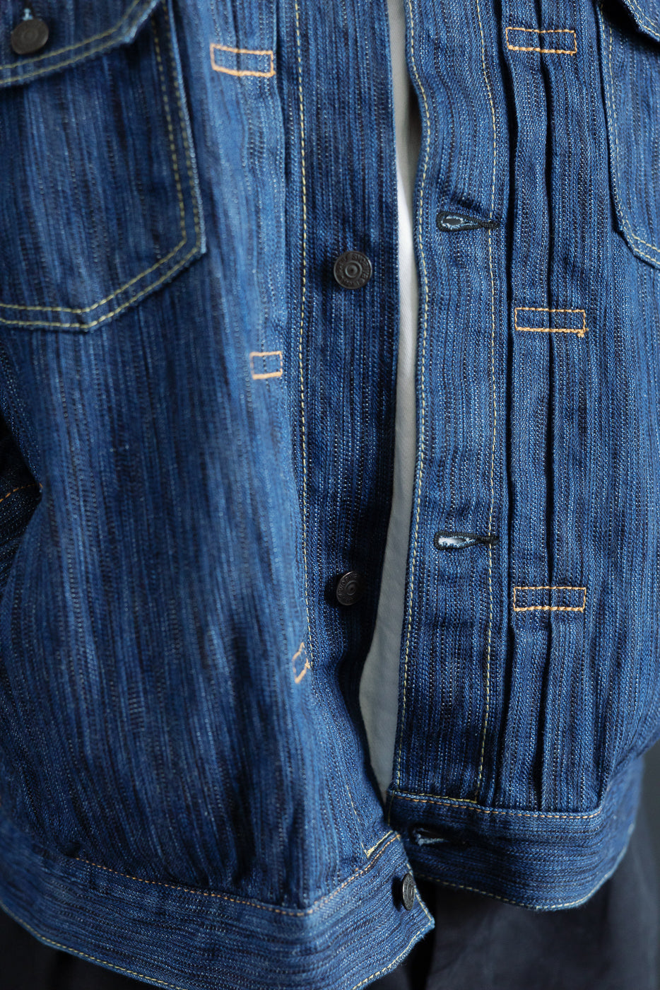 Close-up of the 6225-L Light Waterfall Selvedge Type II Jacket in Indigo, showcasing its textured Japanese denim, metal buttons, contrast stitching on chest pockets, and selvedge detailing along the placket.