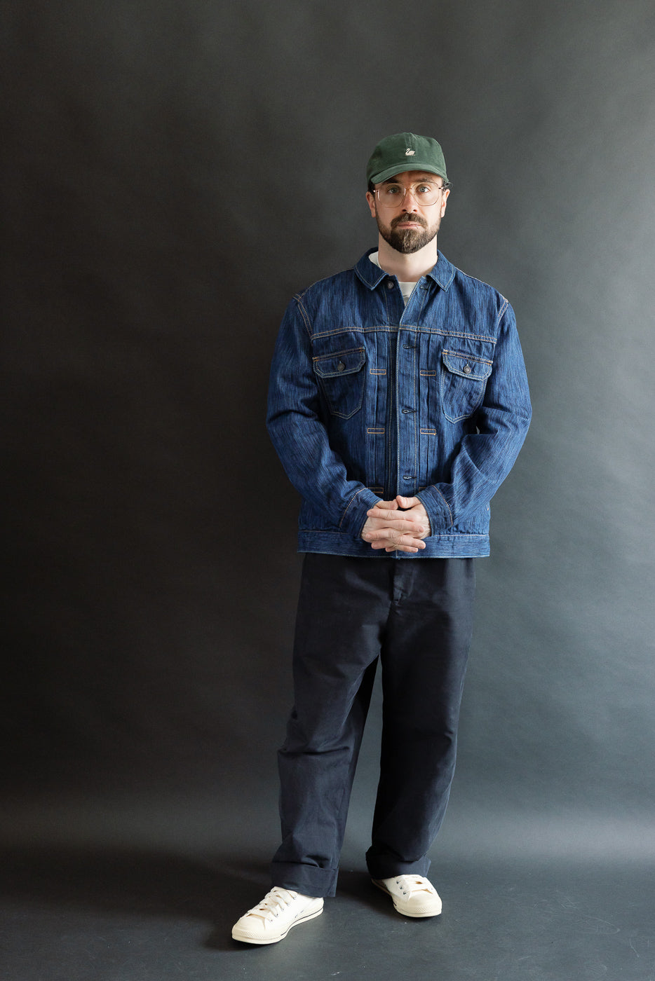 Man wearing the 6225-L - 14.5oz Light Waterfall Selvedge Type II Jacket in Indigo, showcasing its classic Type-II silhouette with distinctive selvedge detailing and signature leaf embroidery, styled casually with denim and sneakers.