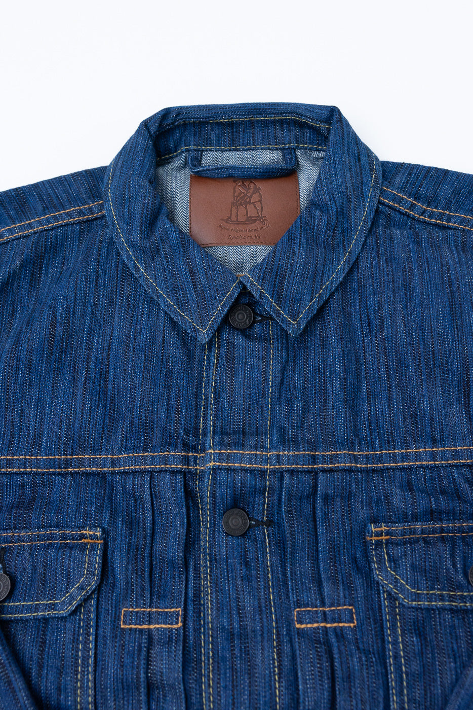 6225-L - 14.5oz Light Waterfall Selvedge Type II Jacket - Indigo; blue denim jacket with point collar, black snap buttons, yellow stitching, chest flap pockets, and visible brown leather neck label, showcasing Japanese craftsmanship.