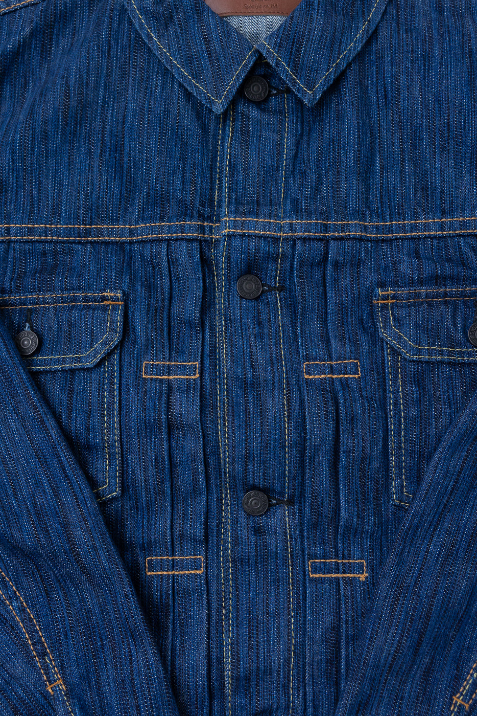 Close-up of the 6225-L - 14.5oz Light Waterfall Selvedge Type II Jacket, showcasing blue striped denim, pointed collar, dark metal buttons, two chest flap pockets, and contrasting yellow/orange top-stitching.