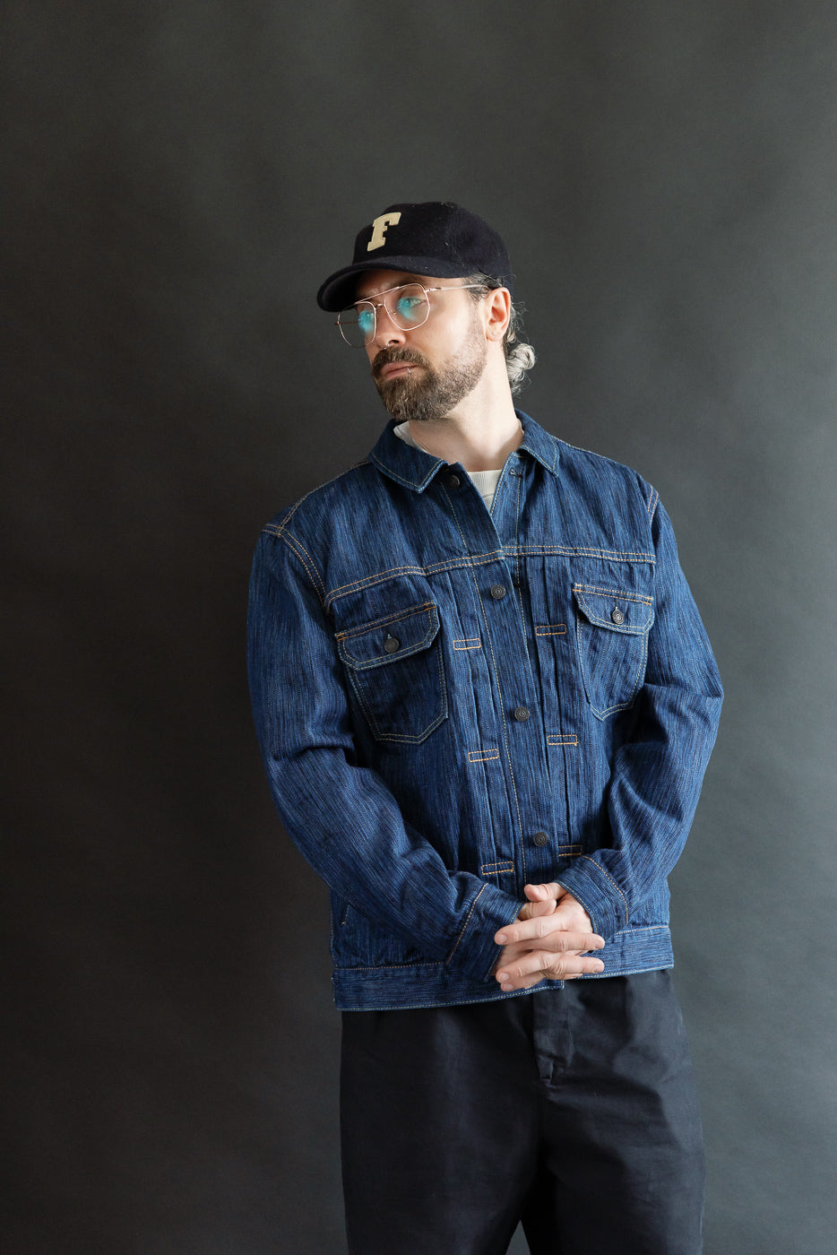 Man wearing the 6225-L - 14.5oz Light Waterfall Selvedge Type II Jacket in Indigo, showcasing its textured Japanese selvedge denim, front flap pockets, and custom iron buttons in a studio portrait.