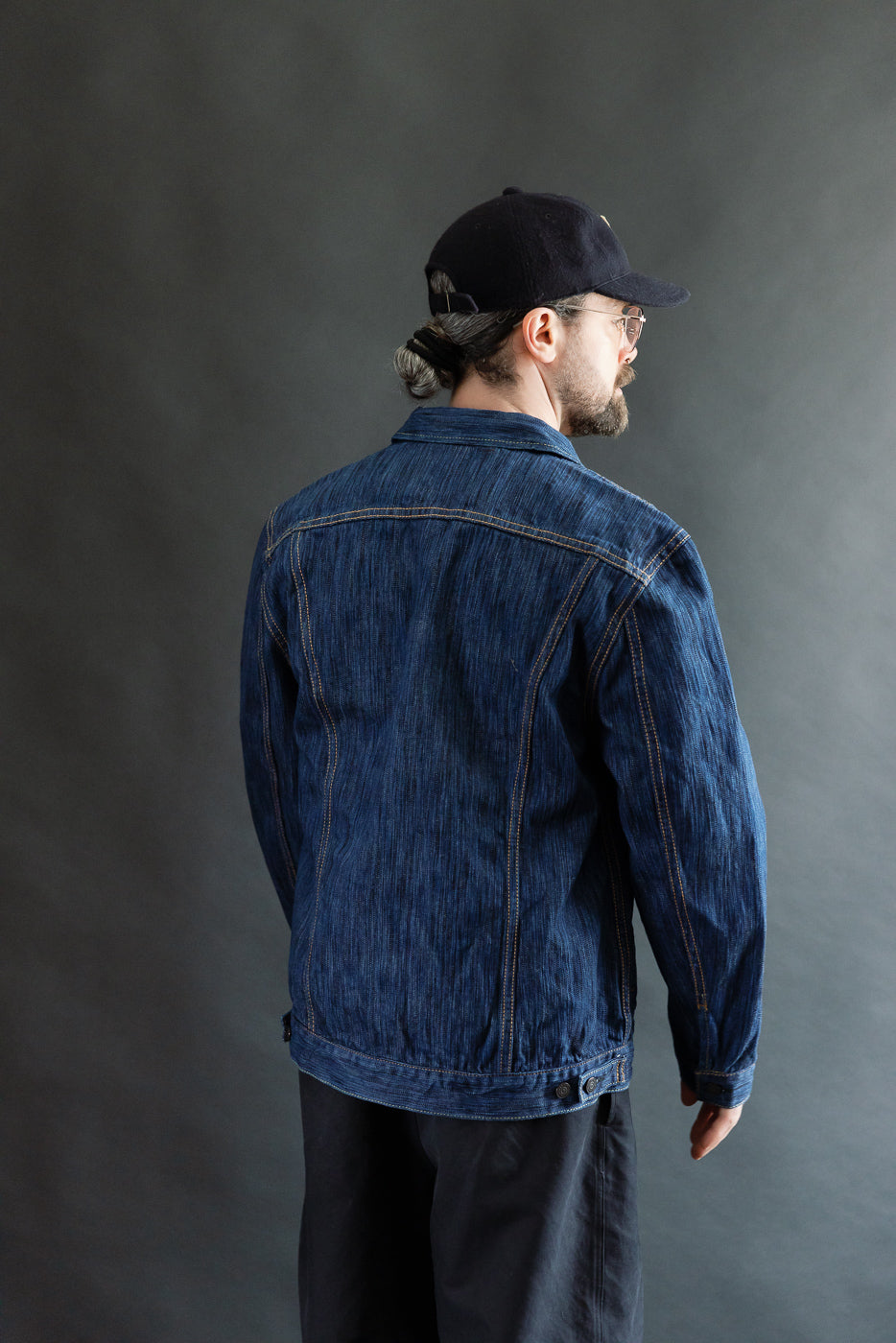Man modeling the 6225-L - 14.5oz Light Waterfall Selvedge Type II Jacket - Indigo, showcasing its streamlined fit, contrast stitching, and signature leaf embroidery, with hand-warmer pockets and custom branded buttons.