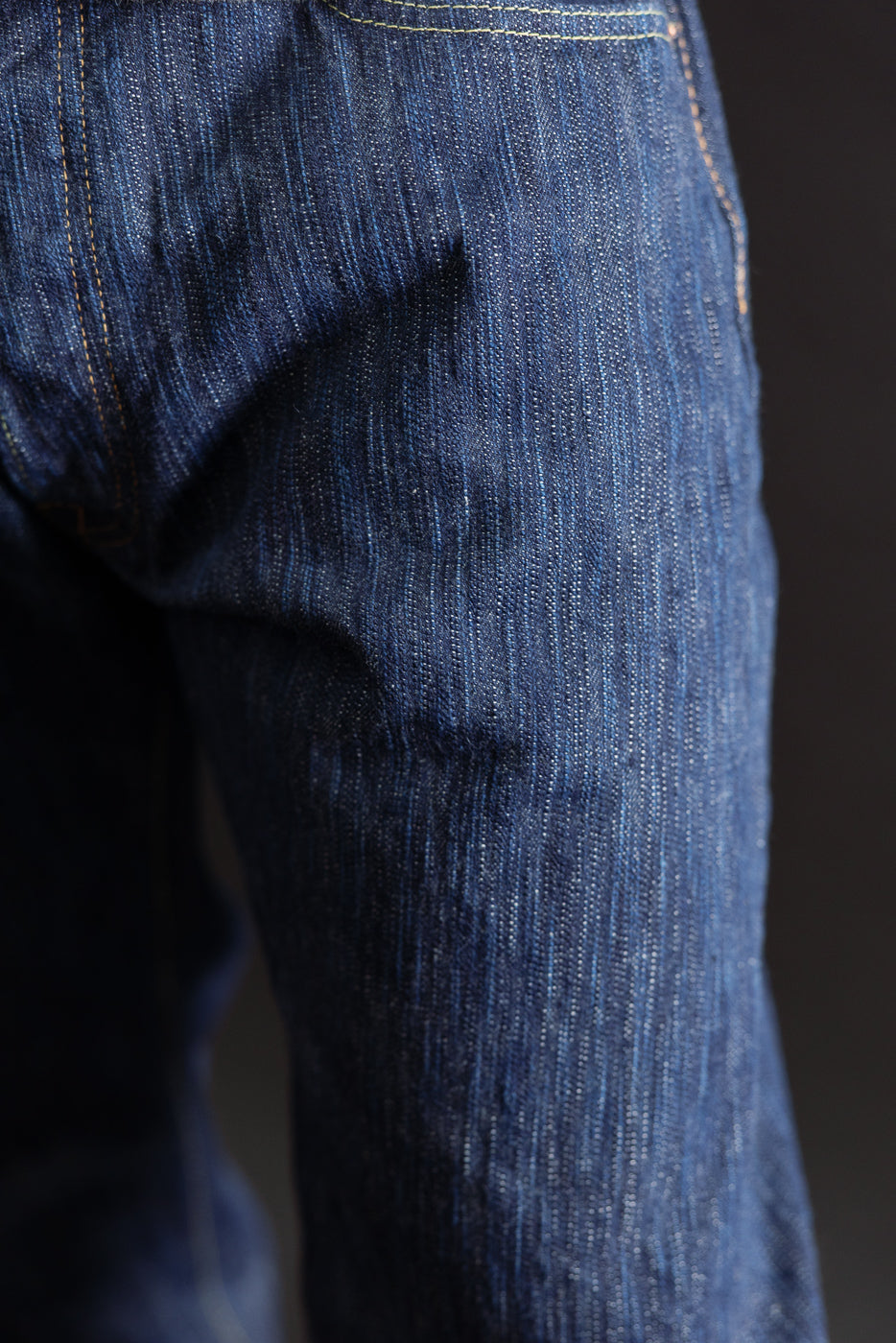 Close-up of the side and back fabric texture of blue selvedge denim jeans.