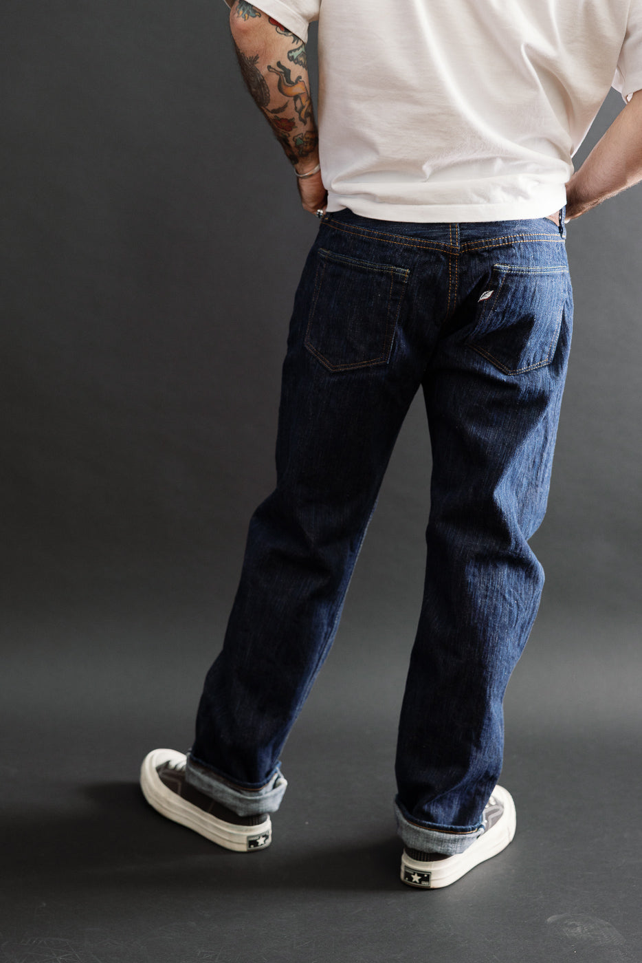 Back view of dark indigo selvedge jeans on male model, 5'9