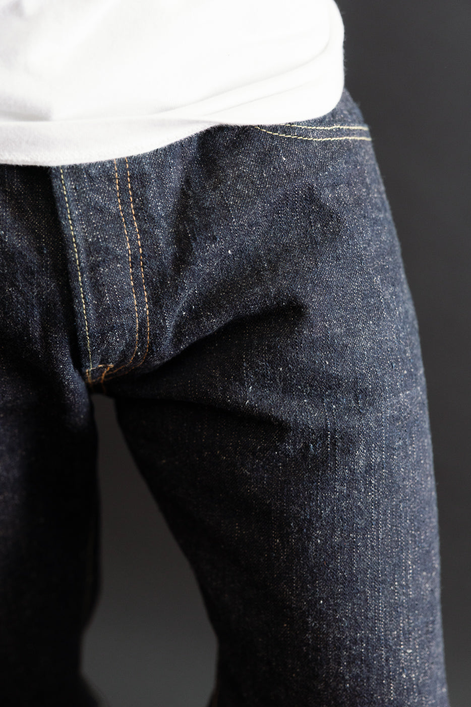 Close-up front view of raw indigo denim jeans texture on a male model, 5'9