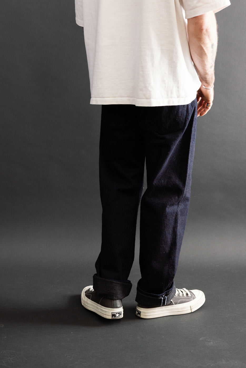 Back view of dark blue selvedge pants on a male model, 5'9