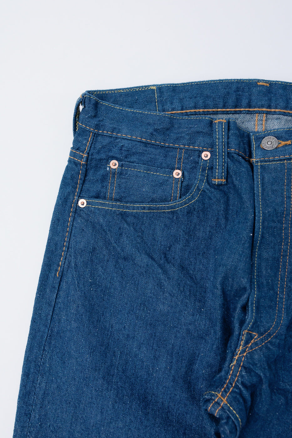 Close-up of front left waist and pocket details on Pure Blue Japan 14oz greencast indigo selvedge jeans.
