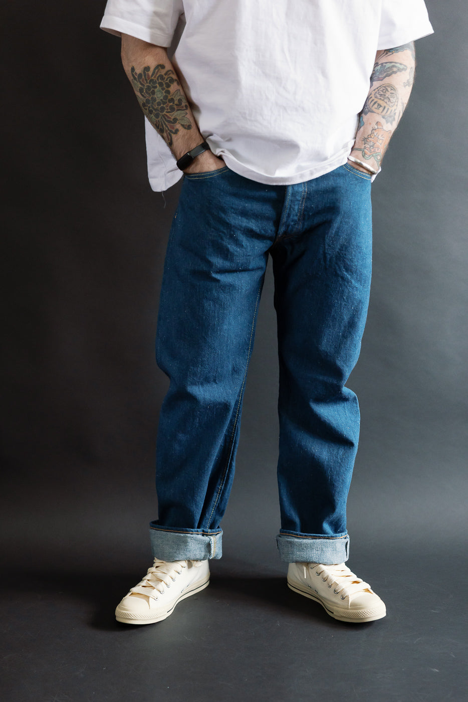 Male model 5'9 165lbs athletic build wearing Pure Blue Japan GRE-003 14oz greencast indigo selvedge jeans, front view, regular straight fit, cuffed hem, on-body partial body shot