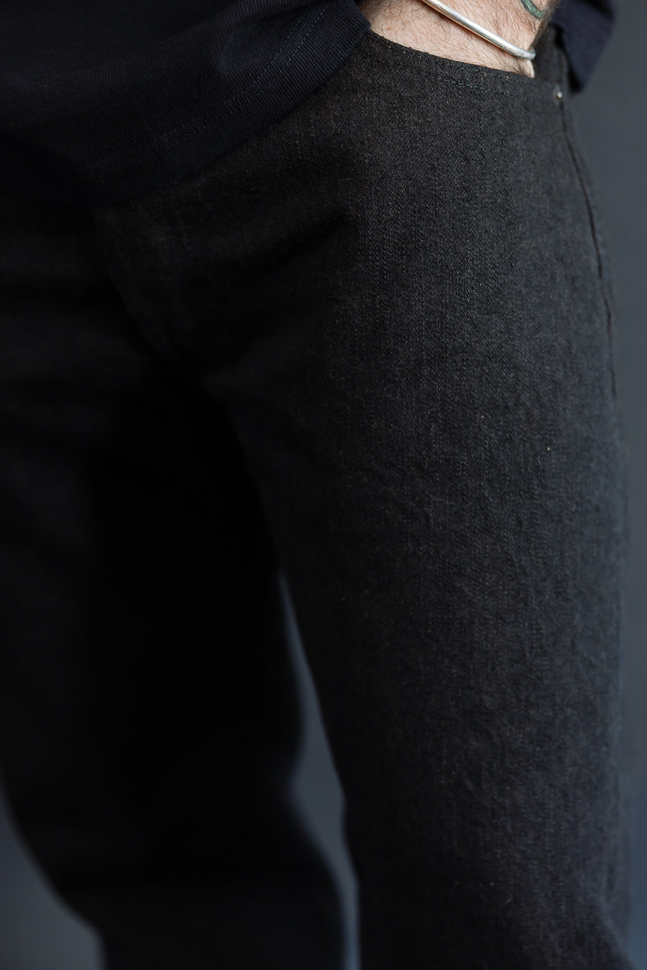 Close-up front view of dark selvedge trousers on male model, 5'9
