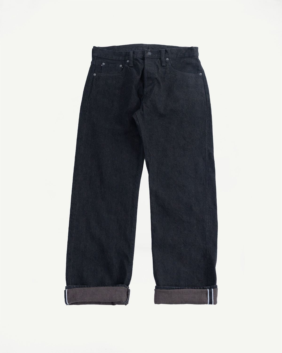 Front view flat lay of dark selvedge denim jeans with cuffed hems showing white selvedge ID, classic 5-pocket design